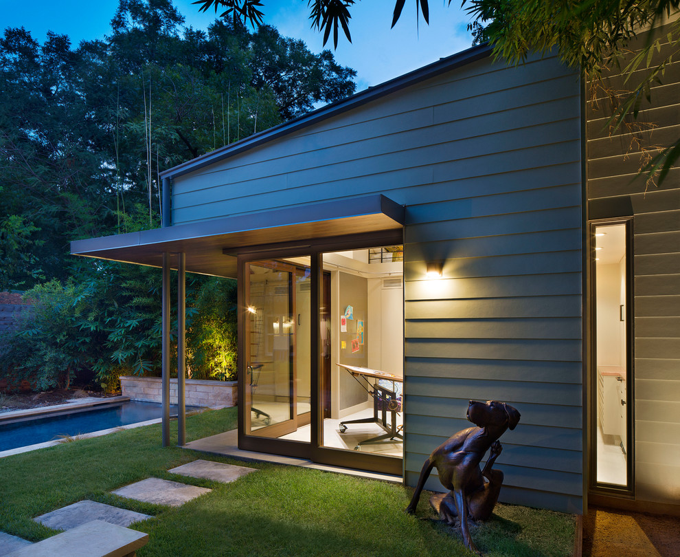 Bild på ett litet funkis grönt hus, med allt i ett plan, fiberplattor i betong och pulpettak