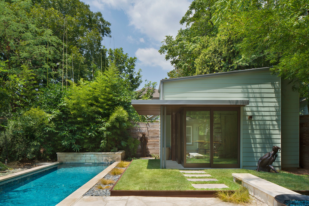 На фото: одноэтажный, зеленый, маленький дом в современном стиле с облицовкой из ЦСП и односкатной крышей для на участке и в саду с