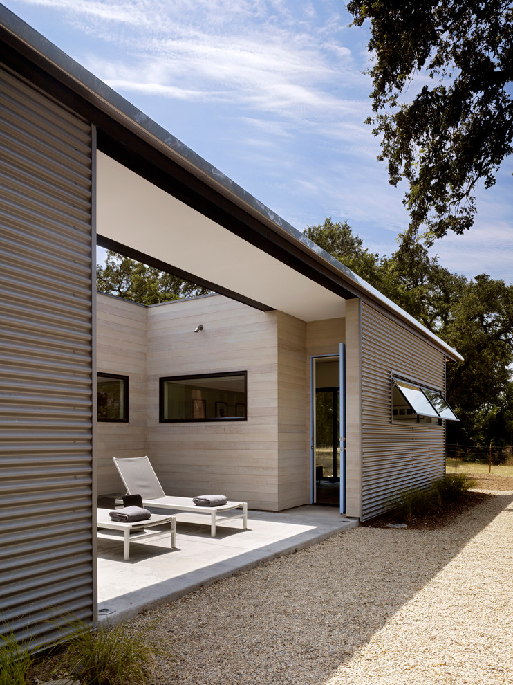Источник вдохновения для домашнего уюта: маленький, одноэтажный, серый дом в стиле модернизм с облицовкой из металла и плоской крышей для на участке и в саду