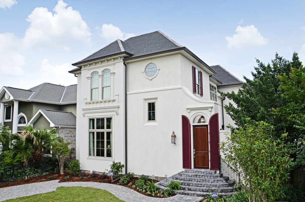 Example of a mid-sized classic beige two-story stucco exterior home design in New Orleans