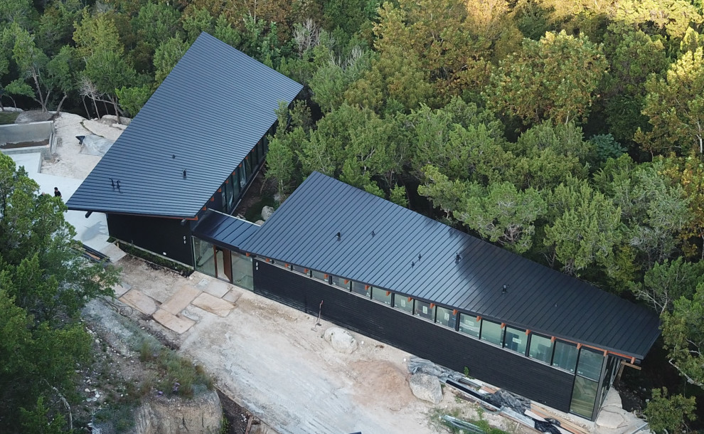 Modernes Haus mit Flachdach, Blechdach und schwarzem Dach in Austin