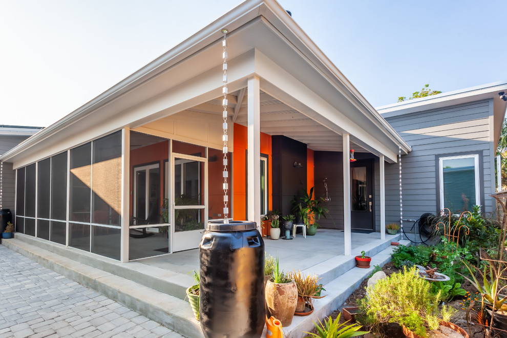 Mid-sized trendy gray one-story concrete fiberboard house exterior photo in New Orleans with a shed roof and a metal roof
