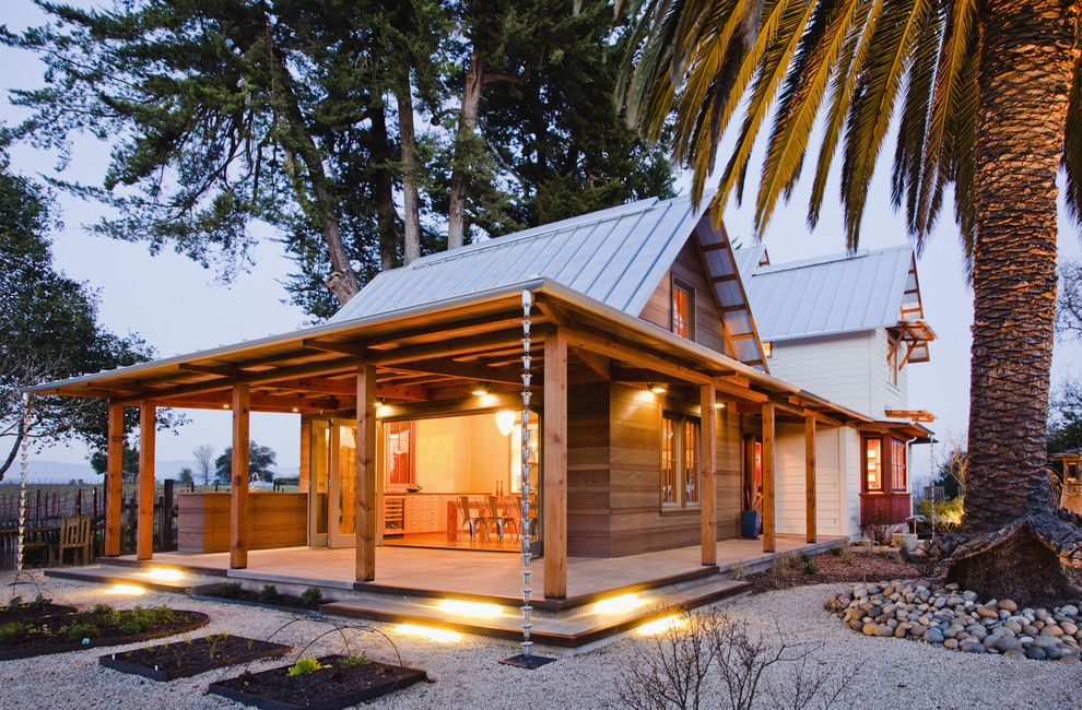 Ispirazione per la facciata di una casa country di medie dimensioni con rivestimento in legno e tetto a capanna