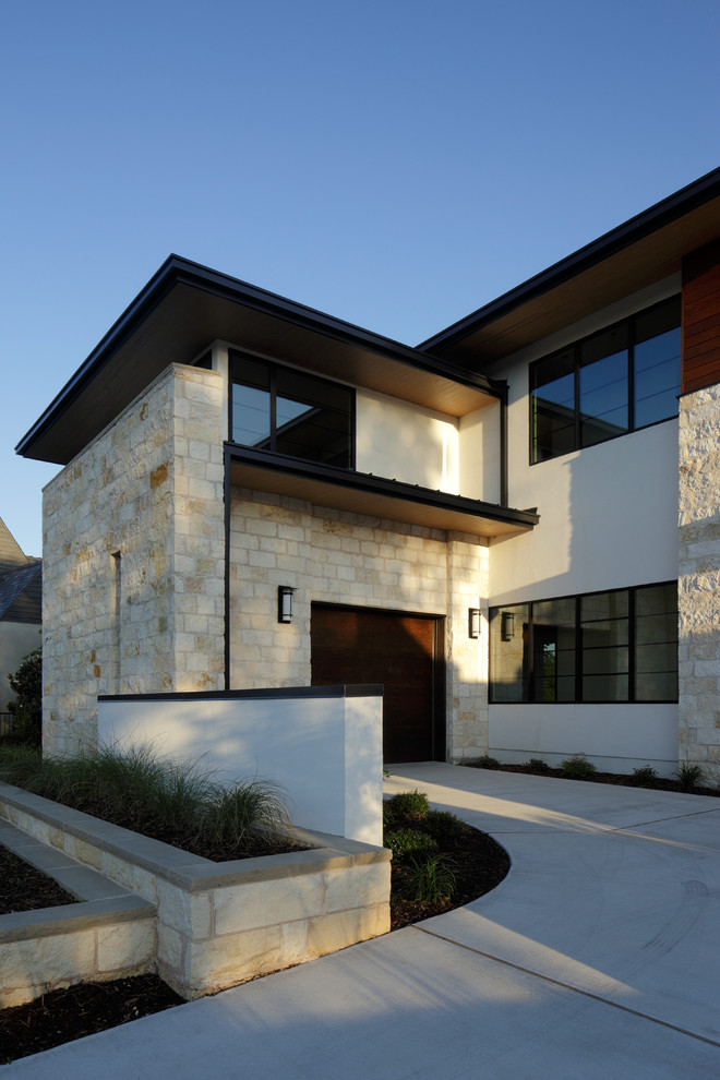 Imagen de fachada beige moderna grande de dos plantas con revestimiento de piedra y tejado plano