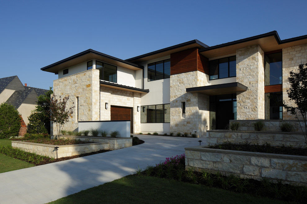 Ejemplo de fachada beige moderna grande de dos plantas con revestimiento de piedra y tejado plano