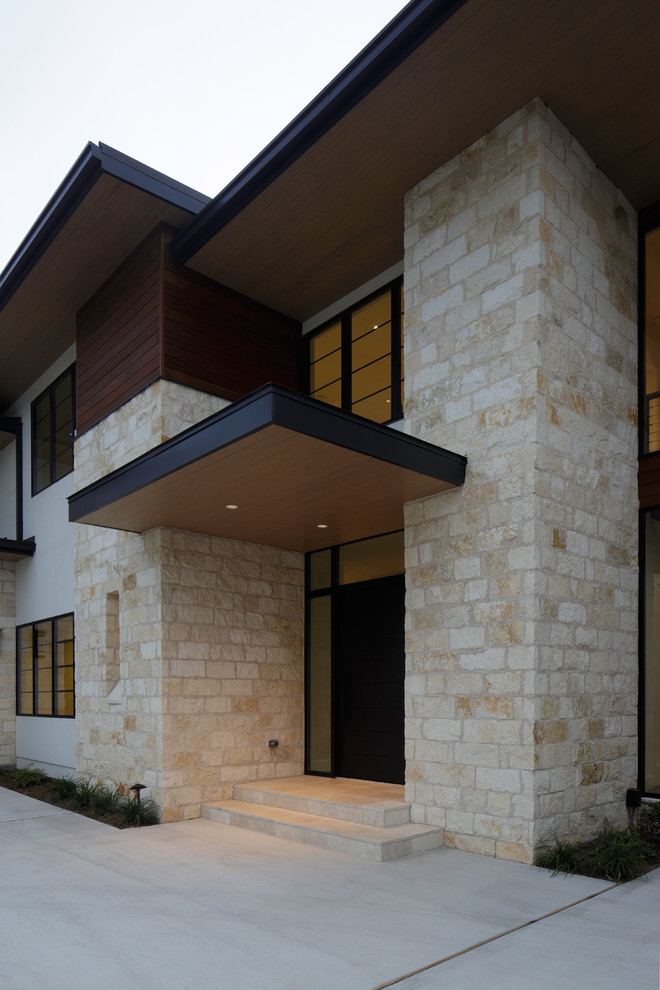 Diseño de fachada beige minimalista grande de dos plantas con revestimiento de piedra y tejado plano