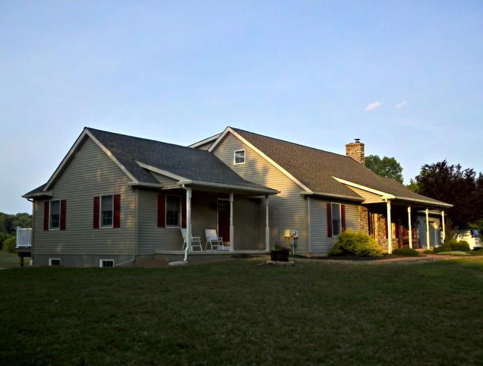 На фото: одноэтажный, коричневый дом среднего размера в классическом стиле с облицовкой из винила и двускатной крышей с