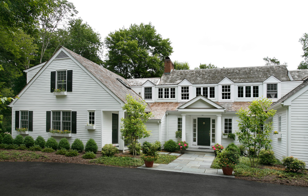 Modelo de fachada de casa blanca tradicional extra grande de dos plantas con revestimiento de madera y tejado de teja de madera