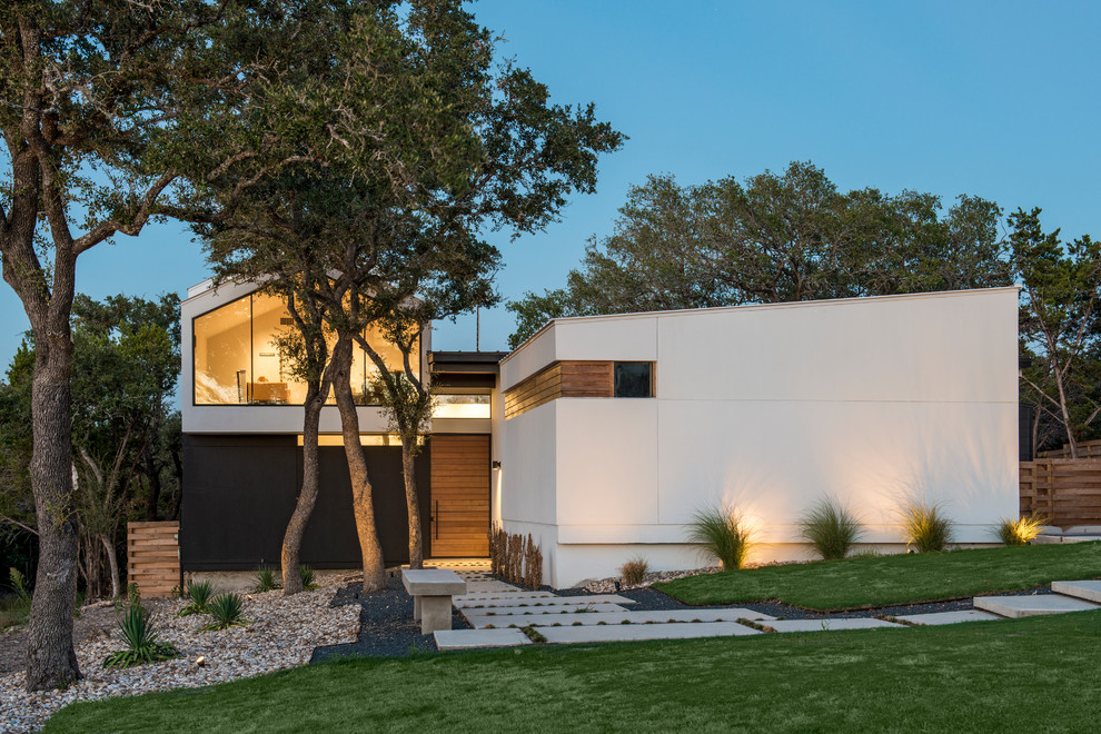 Inspiration for a contemporary white two-story exterior home remodel in Austin with a shed roof