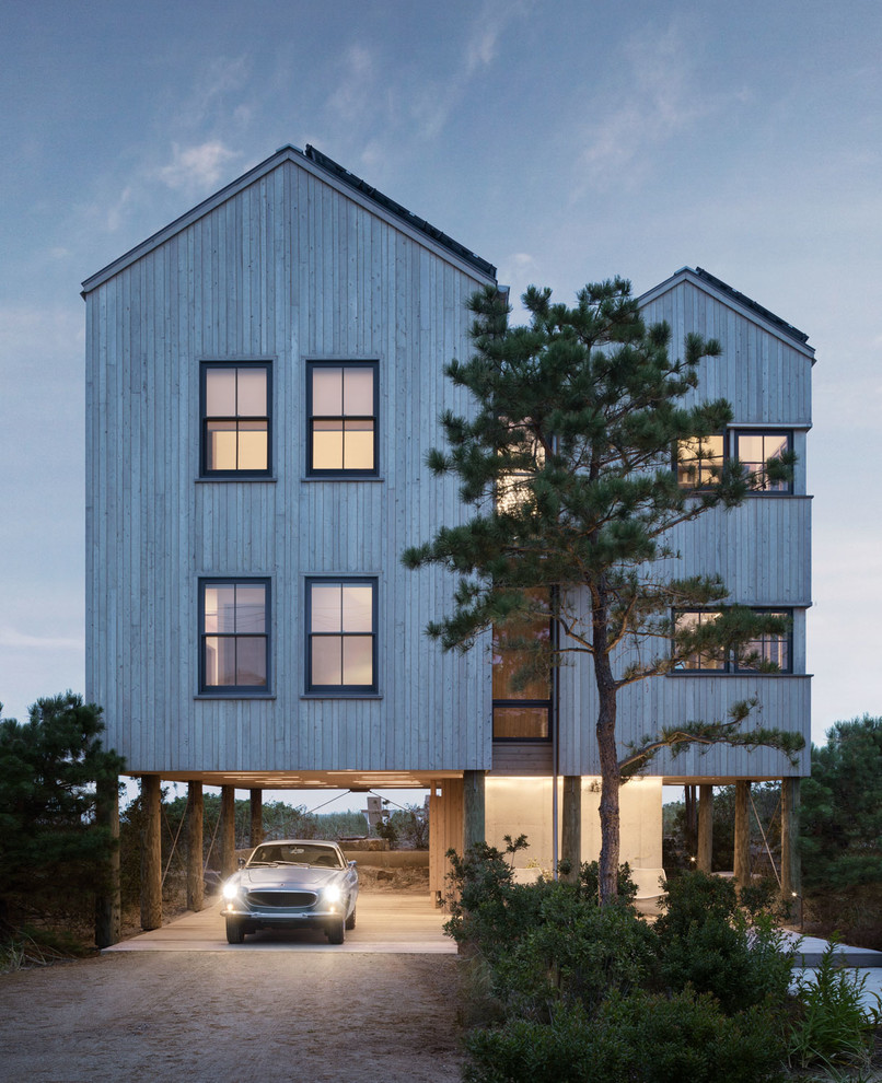 Imagen de fachada de casa beige costera de tres plantas con revestimiento de madera, tejado a dos aguas y tejado de metal