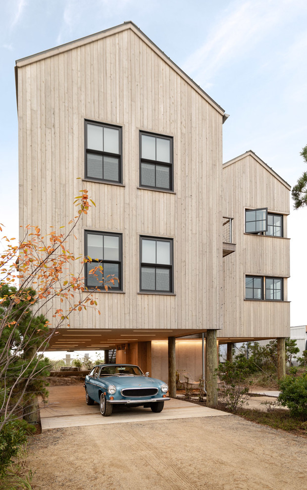 Ejemplo de fachada de casa beige costera de dos plantas con revestimiento de madera y tejado a dos aguas