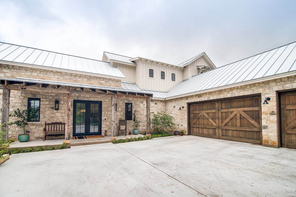 Example of a large farmhouse beige two-story mixed siding exterior home design in Austin with a metal roof