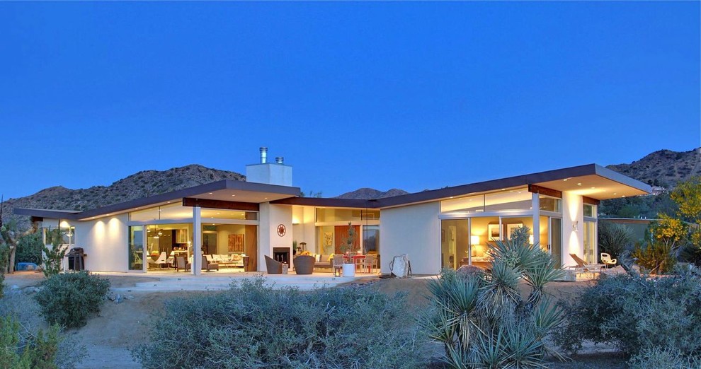 Example of a mid-sized mid-century modern white one-story exterior home design in Other with a butterfly roof