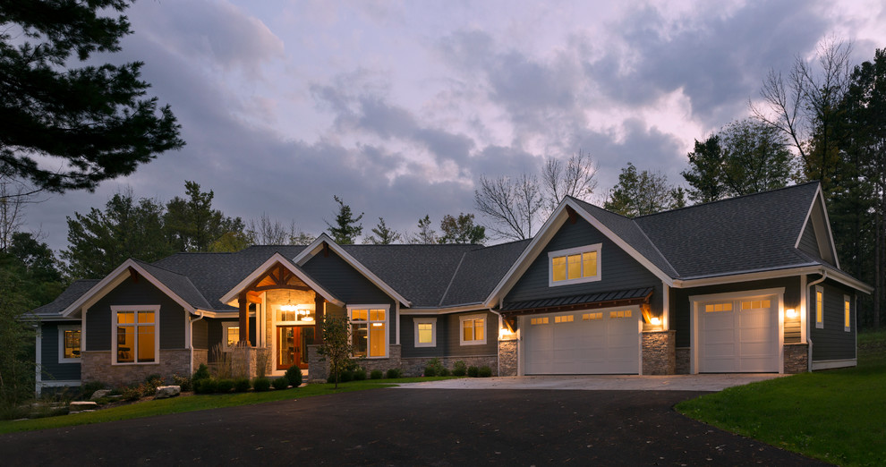 Cette image montre une grande façade de maison bleue craftsman en béton de plain-pied avec un toit à deux pans.