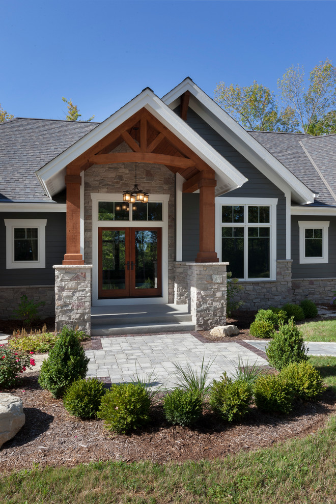 Large arts and crafts gray one-story concrete exterior home photo in Milwaukee with a shingle roof