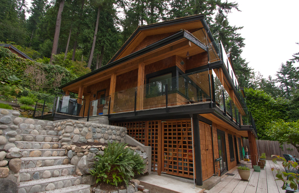 Exemple d'une façade de maison marron bord de mer en bois à un étage.