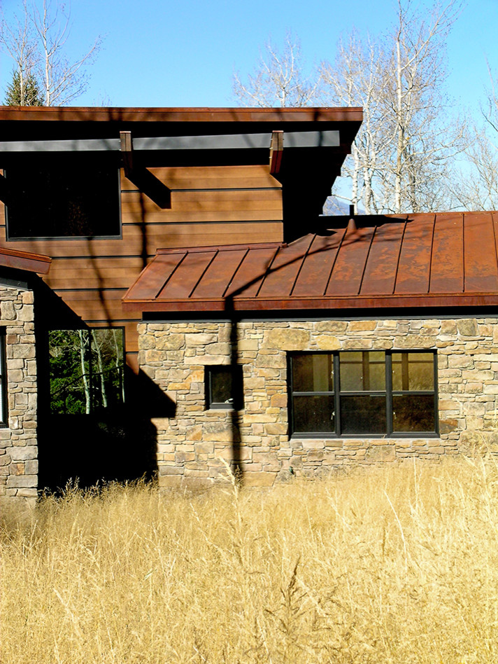 Diseño de fachada de casa marrón contemporánea grande de dos plantas con revestimientos combinados y tejado de metal