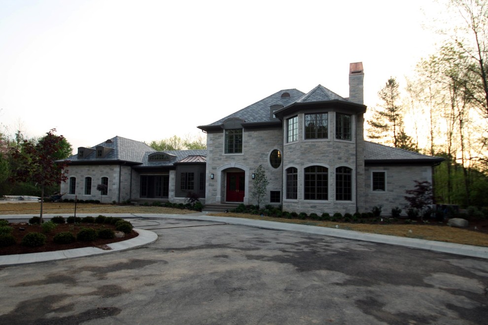 Foto della facciata di una casa grande grigia moderna a due piani con rivestimento in pietra
