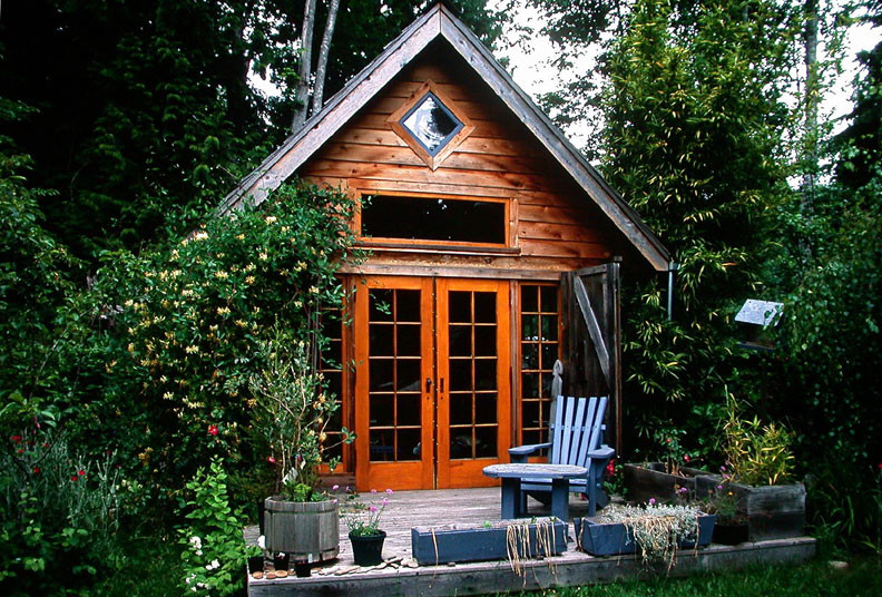 На фото: маленький, одноэтажный, деревянный, коричневый дом в стиле рустика с двускатной крышей для на участке и в саду