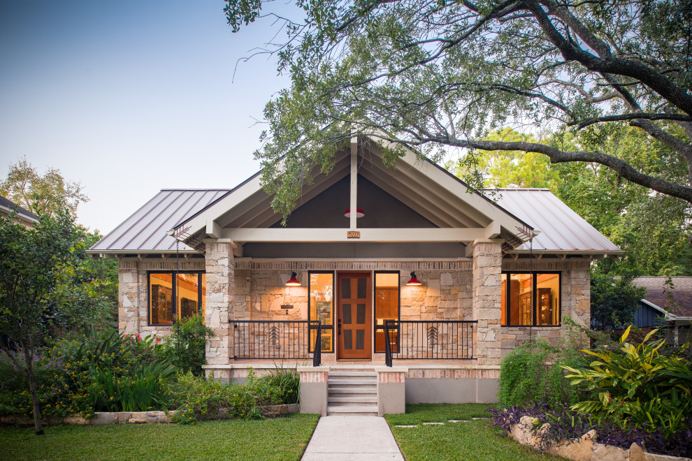 This is an example of a traditional detached house in Austin with stone cladding and a metal roof.