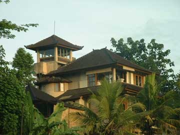 Foto della facciata di una casa beige tropicale a tre piani con rivestimento in pietra