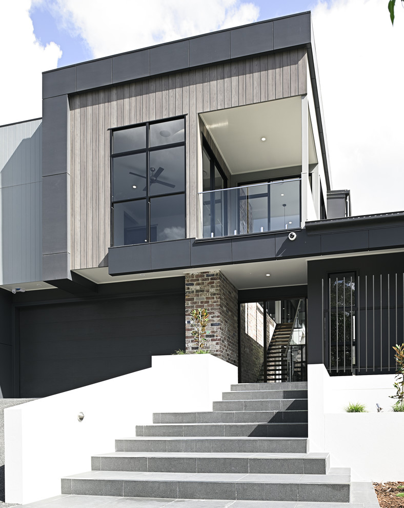 Imagen de fachada de casa gris contemporánea grande de dos plantas con revestimientos combinados, tejado plano y tejado de metal