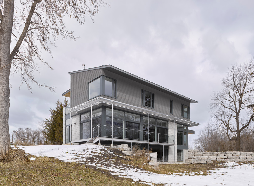 Huge modern gray two-story mixed siding house exterior idea in Ottawa with a shed roof and a metal roof