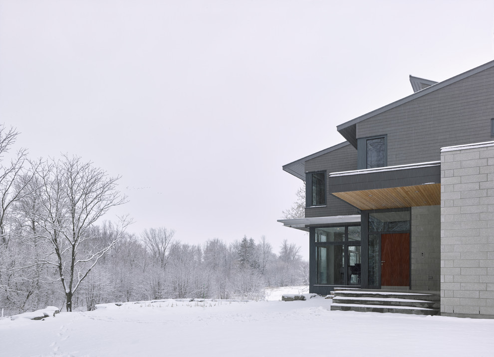 Idées déco pour une très grande façade de maison grise moderne à un étage avec un revêtement mixte, un toit en appentis et un toit en métal.