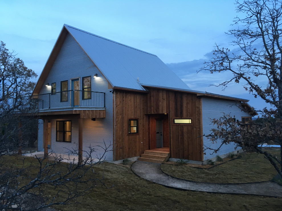 Immagine della facciata di una casa grigia country a due piani di medie dimensioni con rivestimento in metallo e copertura in metallo o lamiera