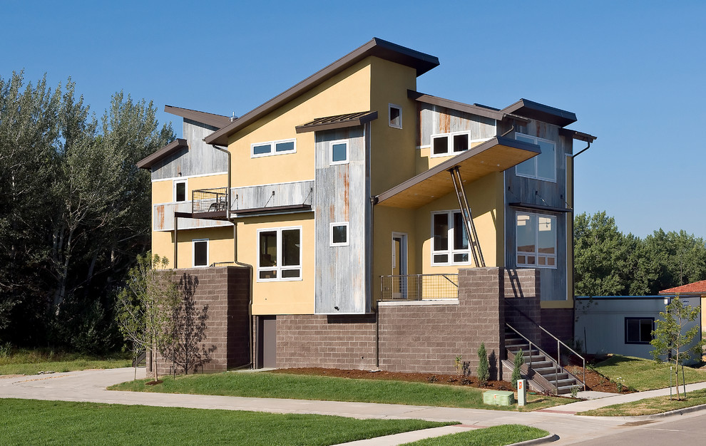 Стильный дизайн: трехэтажный, желтый дом среднего размера в стиле лофт - последний тренд