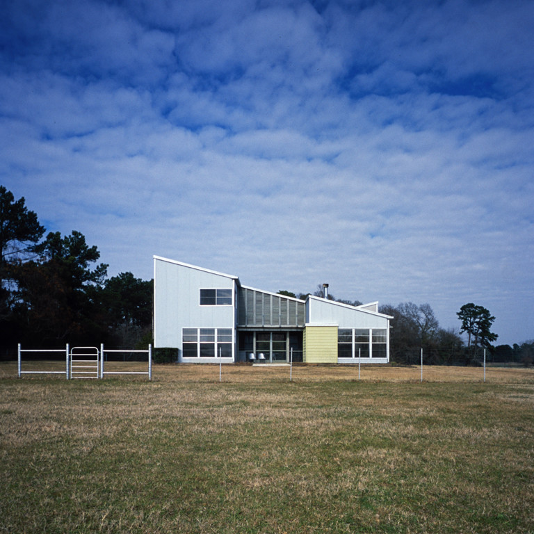 Cette image montre une façade de maison métallique design de taille moyenne et à un étage avec un toit en appentis.