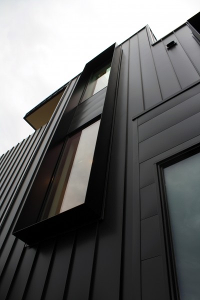 Exemple d'une façade de maison métallique et noire moderne à deux étages et plus avec un toit plat.