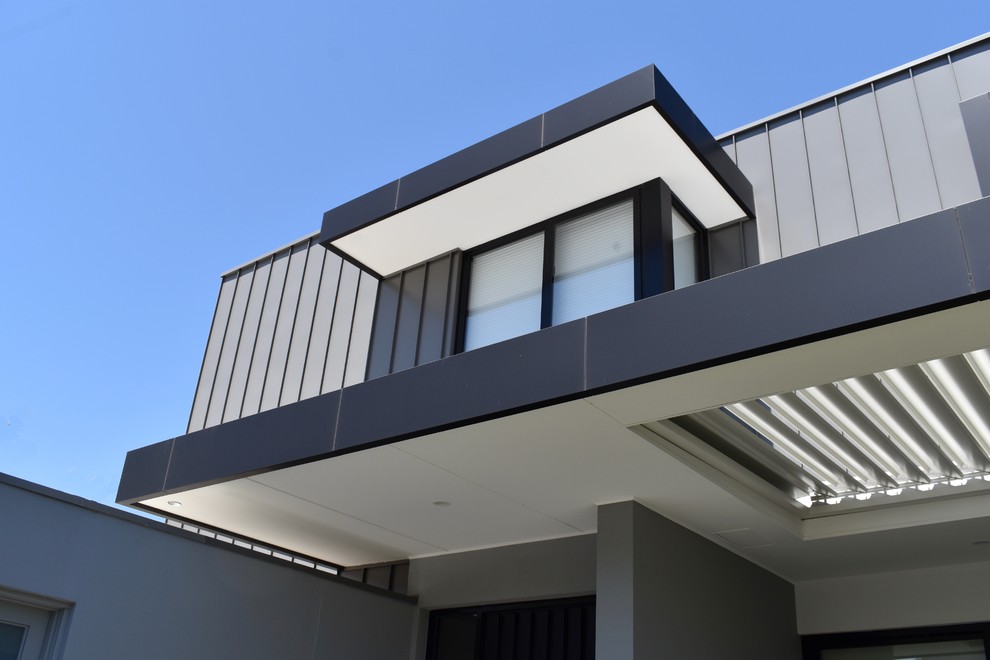 Идея дизайна: двухэтажный, серый таунхаус среднего размера в современном стиле с облицовкой из металла, плоской крышей и металлической крышей