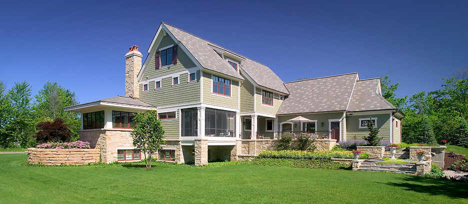 Cette photo montre une grande façade de maison verte chic en panneau de béton fibré à deux étages et plus avec un toit à deux pans.