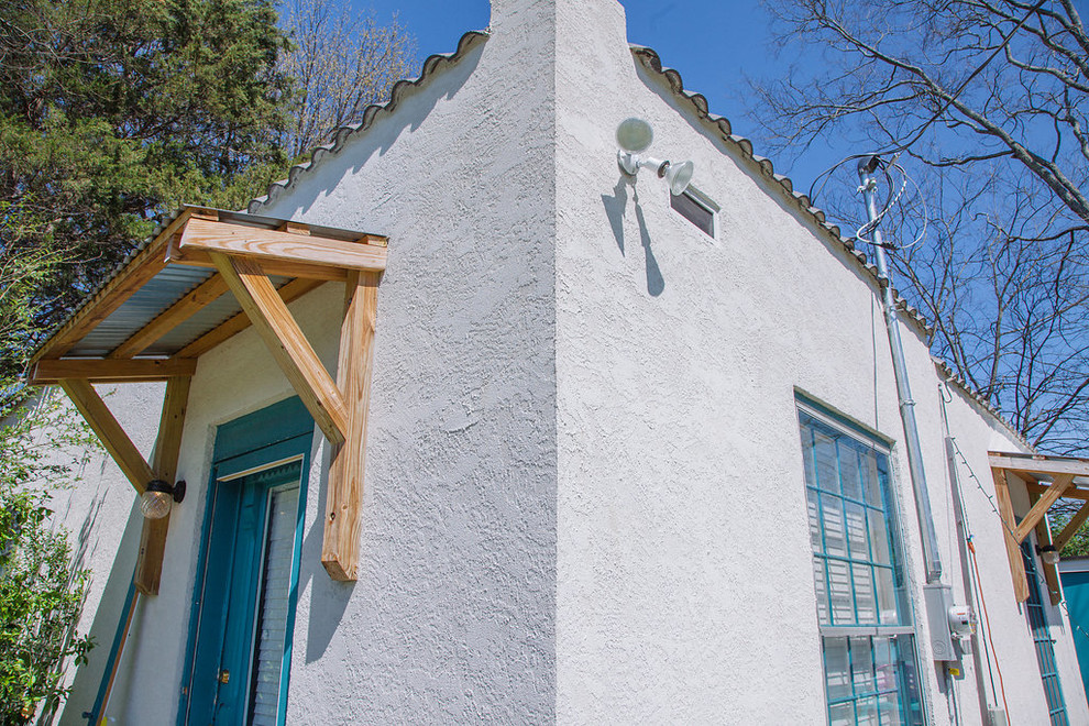 Kleine, Einstöckige Mediterrane Doppelhaushälfte mit Putzfassade, weißer Fassadenfarbe, Flachdach und Schindeldach in Nashville