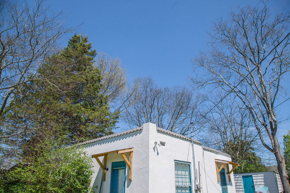 Ejemplo de fachada de casa bifamiliar blanca de estilo americano pequeña de una planta con revestimiento de estuco, tejado plano y tejado de teja de madera