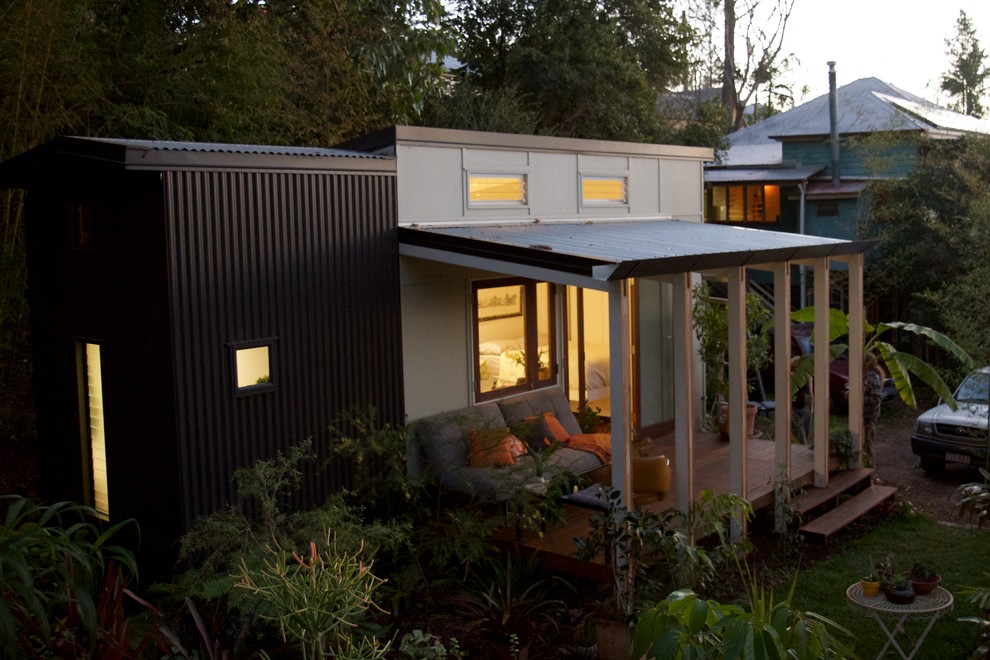 Small and green contemporary split-level house exterior in Brisbane with concrete fibreboard cladding and a lean-to roof.