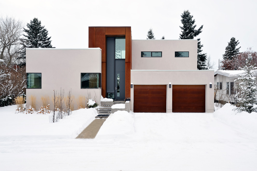 Стильный дизайн: бежевый частный загородный дом в стиле модернизм с облицовкой из цементной штукатурки и плоской крышей - последний тренд