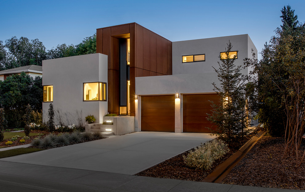 Cette photo montre une façade de maison métallique et beige moderne à un étage avec un toit plat.