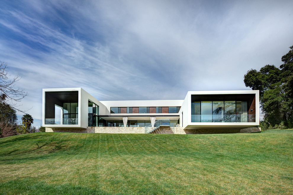 Ispirazione per la facciata di una casa grande bianca moderna a due piani con tetto piano, rivestimento in vetro e scale