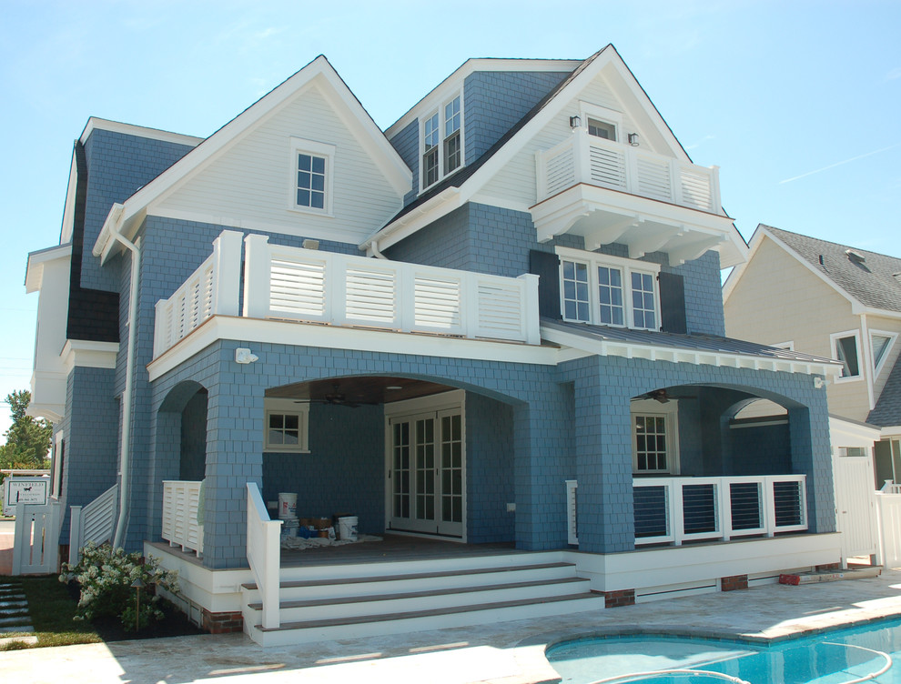 Immagine della facciata di una casa blu stile marinaro a tre piani con rivestimento in legno