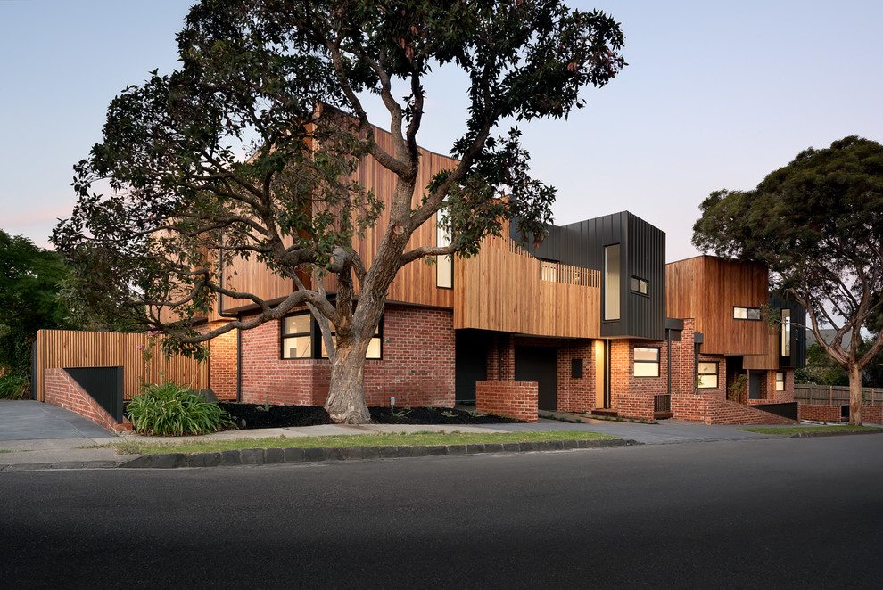 Photo of a medium sized and red contemporary two floor brick house exterior in Melbourne with a flat roof.