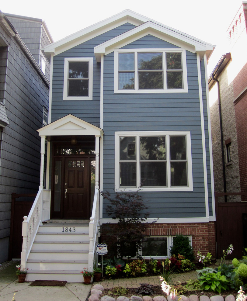 Стильный дизайн: синий, двухэтажный частный загородный дом среднего размера в викторианском стиле с облицовкой из ЦСП, двускатной крышей и крышей из гибкой черепицы - последний тренд