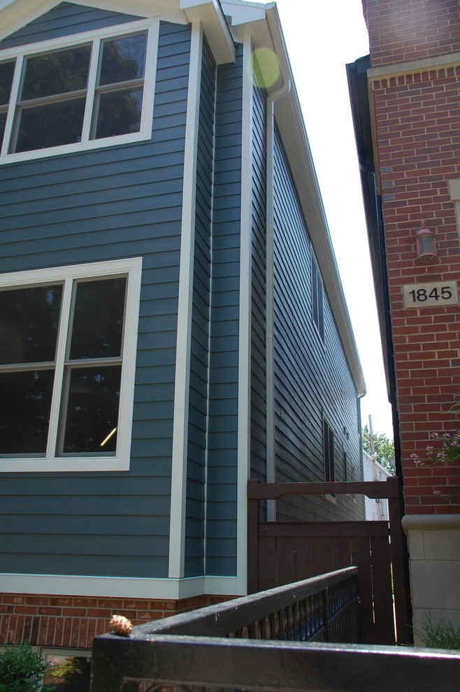 Diseño de fachada de casa azul tradicional de tamaño medio de dos plantas con revestimiento de aglomerado de cemento, tejado a dos aguas y tejado de teja de madera