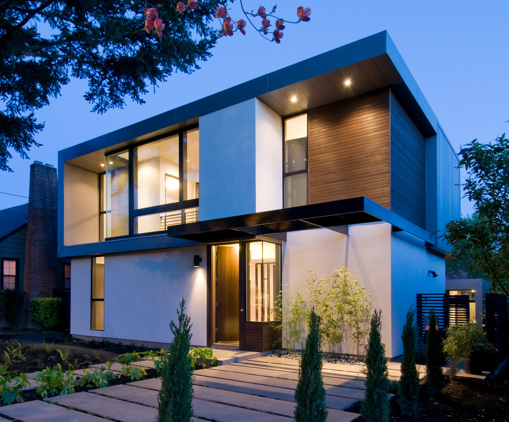 Cette image montre une façade de maison blanche minimaliste de taille moyenne et à un étage avec un revêtement mixte et un toit plat.