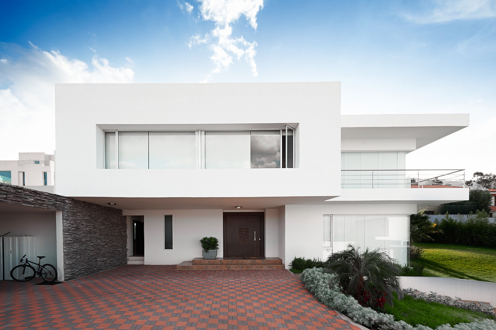Cette photo montre une façade de maison blanche moderne à un étage avec un toit plat.