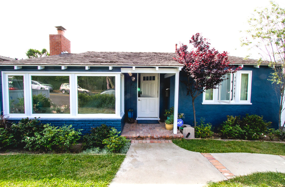 Cette image montre une façade de maison bleue design de taille moyenne et de plain-pied avec un revêtement mixte et un toit en shingle.