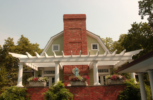 Esempio della facciata di una casa verde classica a due piani di medie dimensioni con rivestimento con lastre in cemento e tetto a padiglione