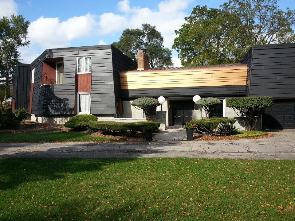 Cette photo montre une façade de maison métallique éclectique avec un toit plat.