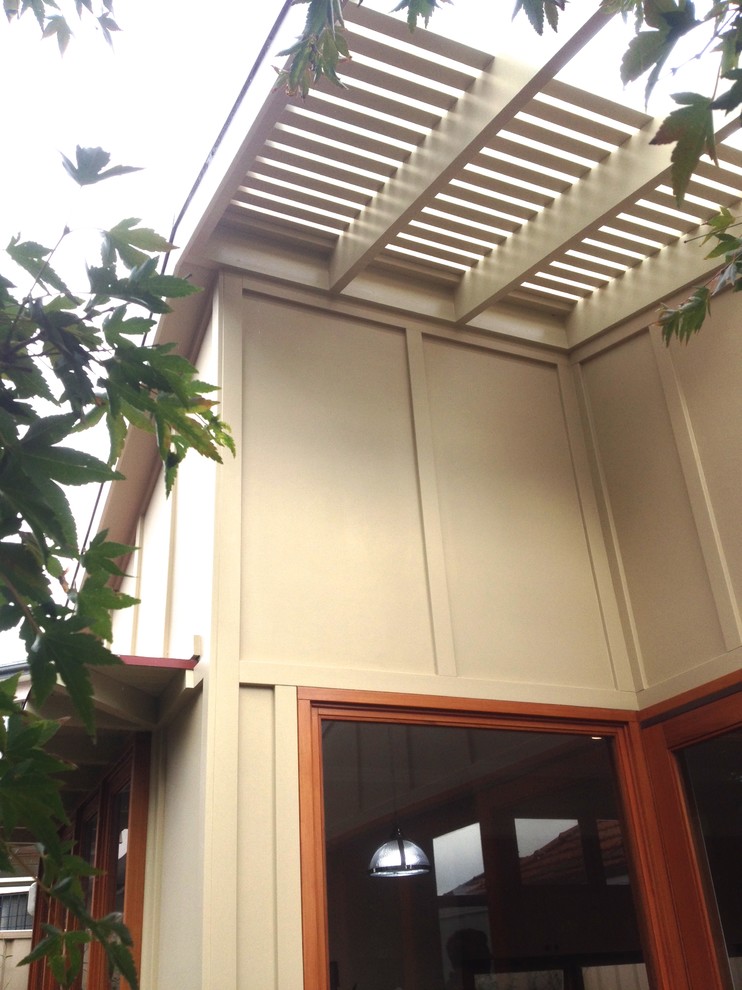 Diseño de fachada beige contemporánea de una planta con revestimiento de aglomerado de cemento